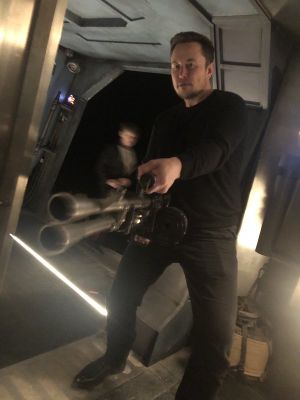 Elon Musk Holding a Minigun: blank meme template